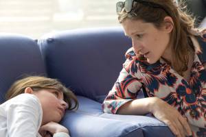 אם ובת בשיחה אינטימית על הספה צילום משפחה רגיש בבית באור טבעי מאת טל גולדשטיין